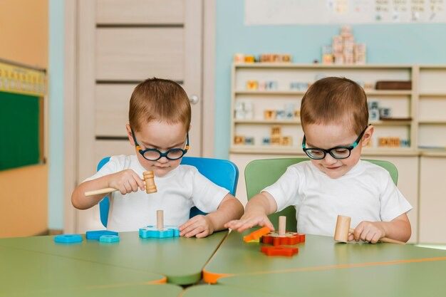 Mother helping a young boy learn with a globe and educational toys at a table in a bright room.