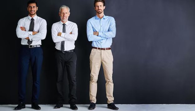 Three businessmen standing with arms crossed against a dark background.

